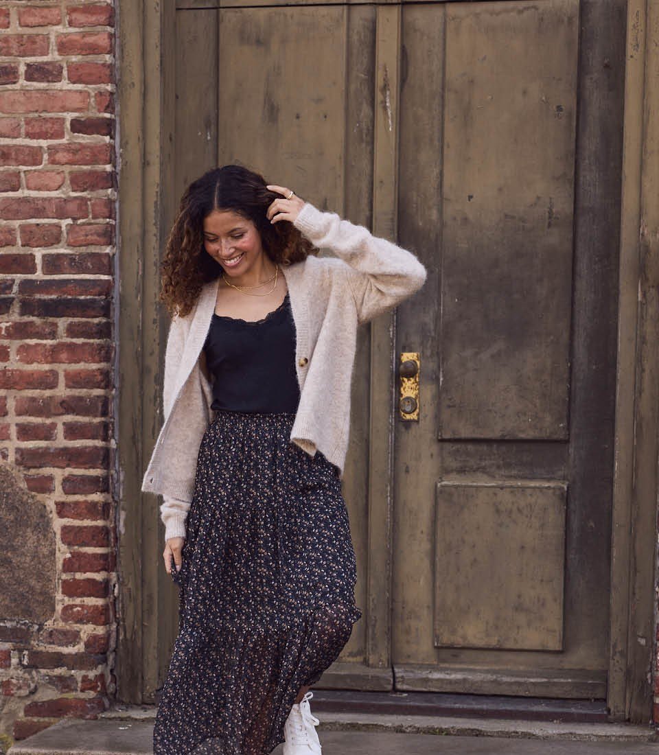 dame i skjørt og cardigan